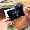 Handmade black suede card holder with blue labradorite gemstone and silver details by Siga Tribal.